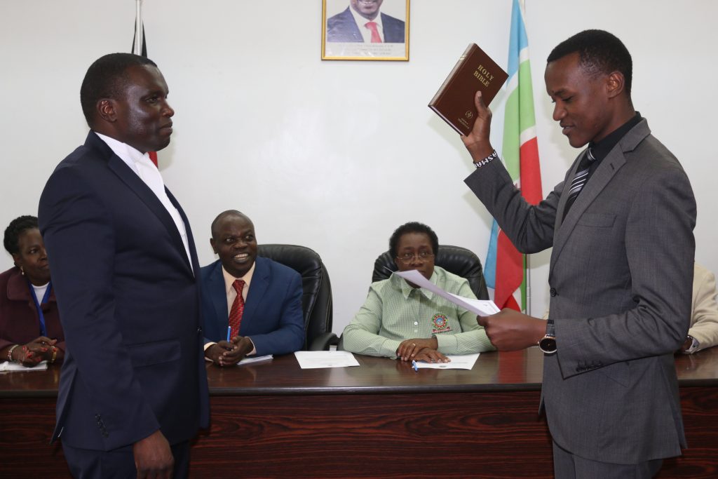 Mr. Robinson taking the oath of office as the Registrar (AA), Dr. Esther Muoria, Deputy Vice Chancellor (AA), Prof. Romanus Odhiambo, and the Vice Chancellor Prof. Mabel Imbuga look on