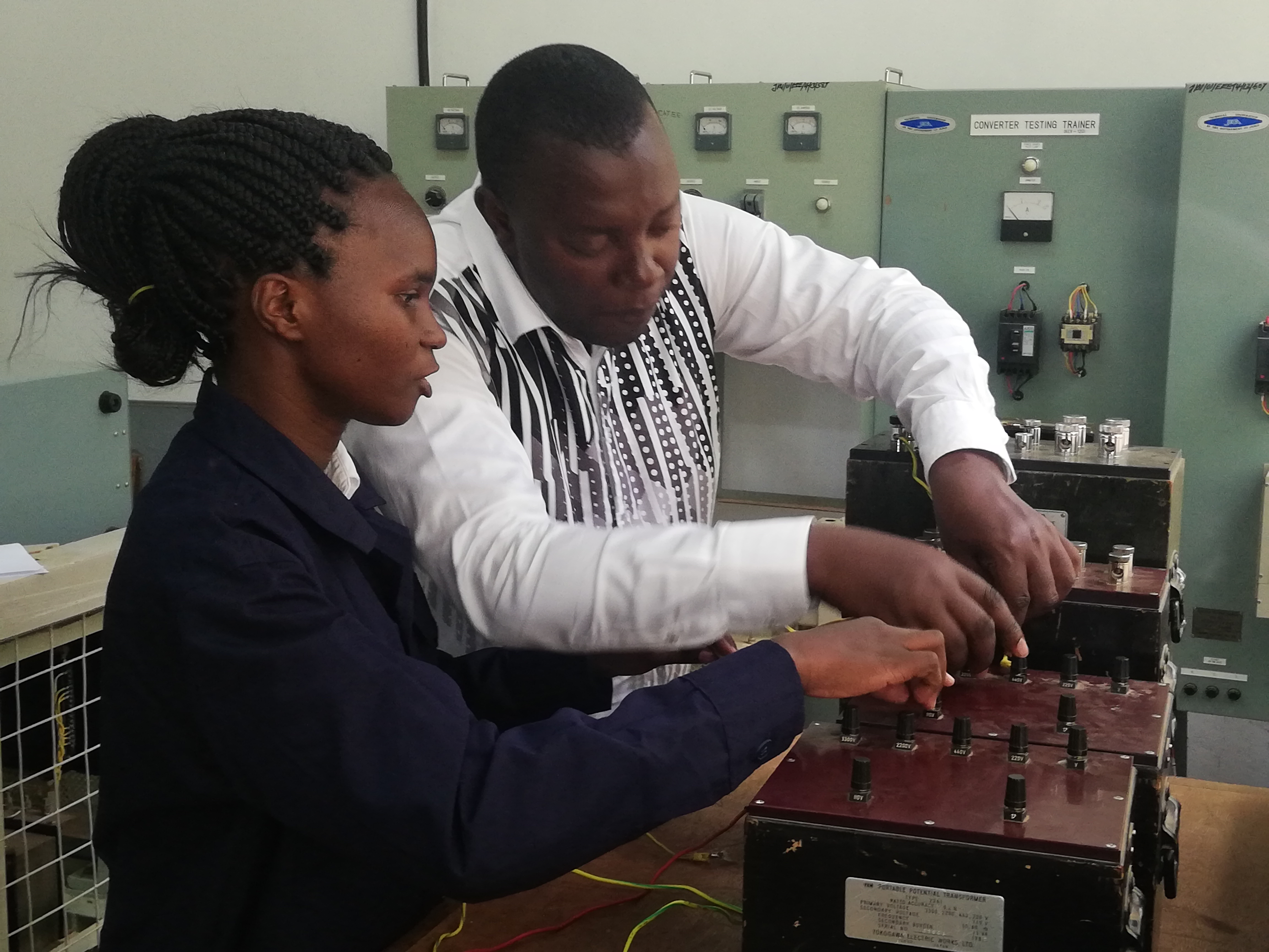 Mr. Peter Maina, a heavy current-machines technologist, instructs-Nyaboke at one of the University EngineeringWorkshops